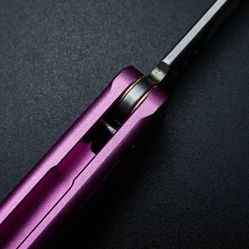 Macro view of Armed Shark Balisong Trainer pivot system with purple aluminum handle.