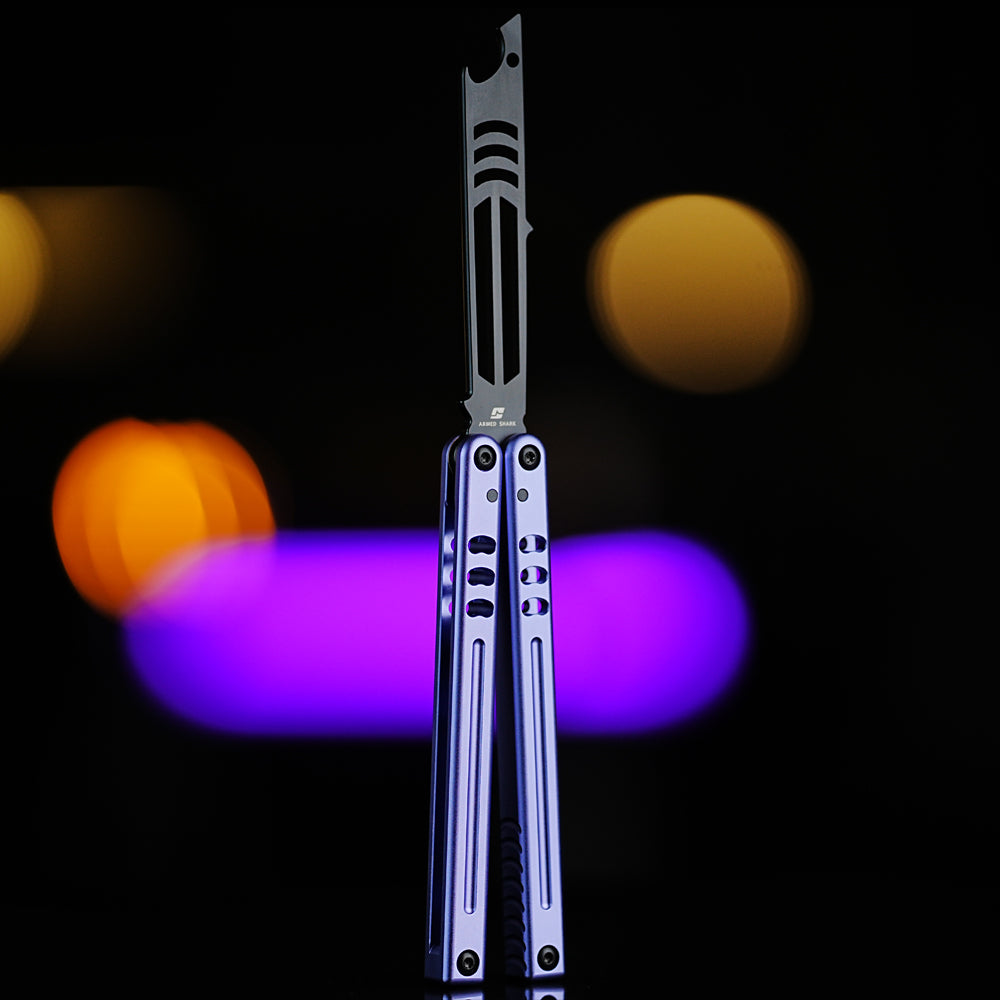 Armed Shark Inked Mako bottle-opener balisong trainer with black training edge and purple anodized handles, front view, studio background.