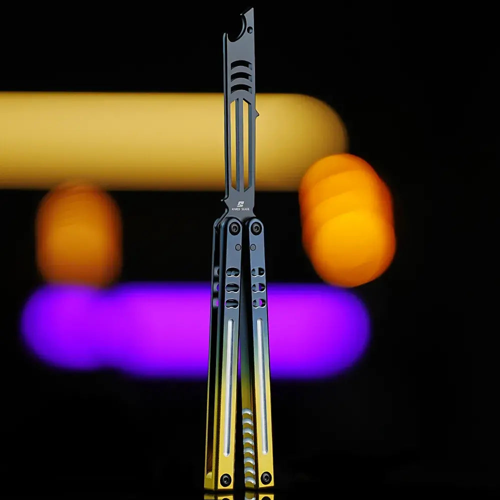 Armed Shark Inked Mako bottle-opener balisong trainer with dark training head and silver-to-gold gradient handles, front view, studio background.