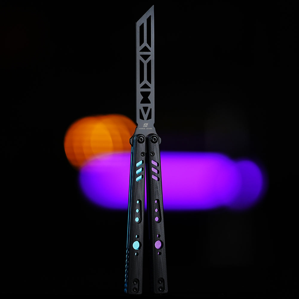 Armed Shark REP V2 Butterfly Trainer with black G10 handle and matte training edge under colorful studio lighting