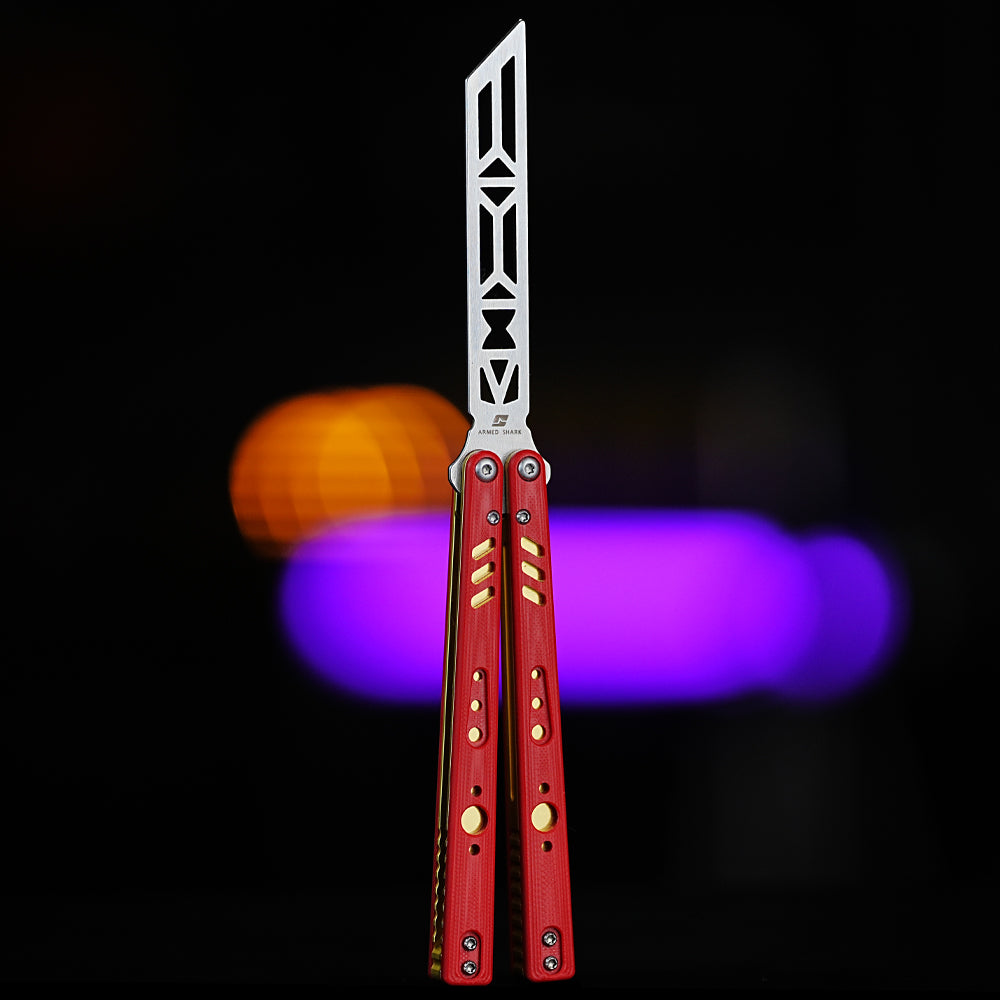 Armed Shark REP V2 Butterfly Trainer with red and gold G10 handles shown in front view under vibrant lighting