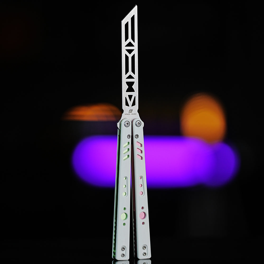 Armed Shark REP V2 Butterfly Trainer with white, pink, and green G10 handles shown in front view under colorful lighting