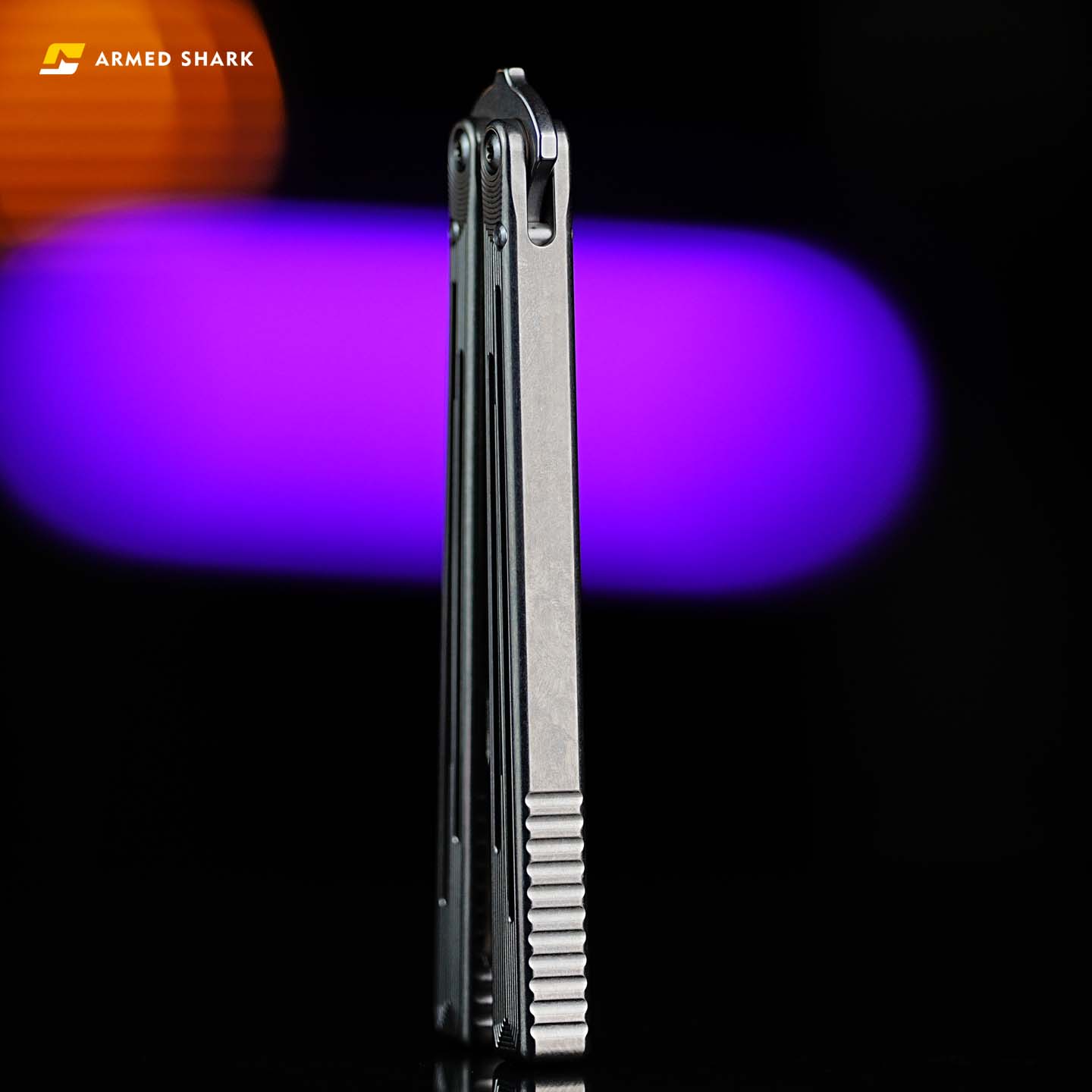 Side view of Armed Shark Titanium Alloy REP/SE Special Edition trainer showing the closed handle with anti-slip grooves and CNC-machined finish against a blurred purple background